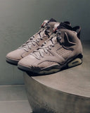 Zapatillas Air Jordan 6 de ante beige y malla con suela de goma translúcida.